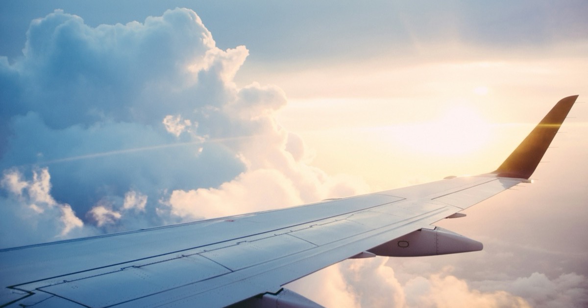 An airliner wing above the clouds at sunset — no airplane has ever been vibe-coded